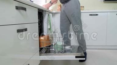 一个男人把<strong>脏盘子</strong>放进洗碗机